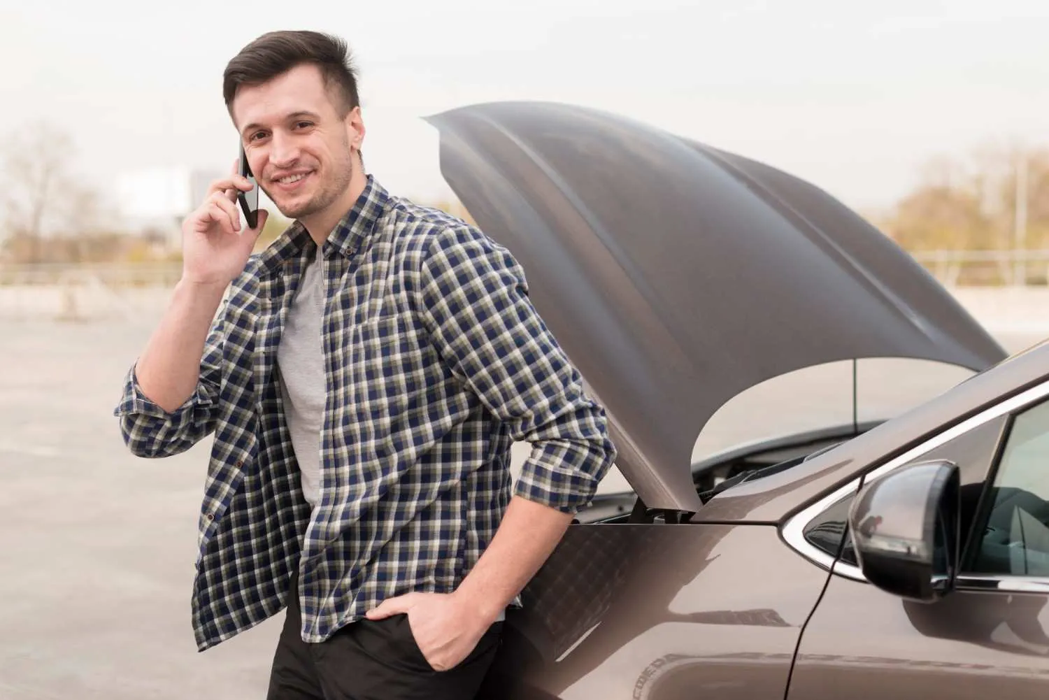 Driver waiting beside a car with the hood up