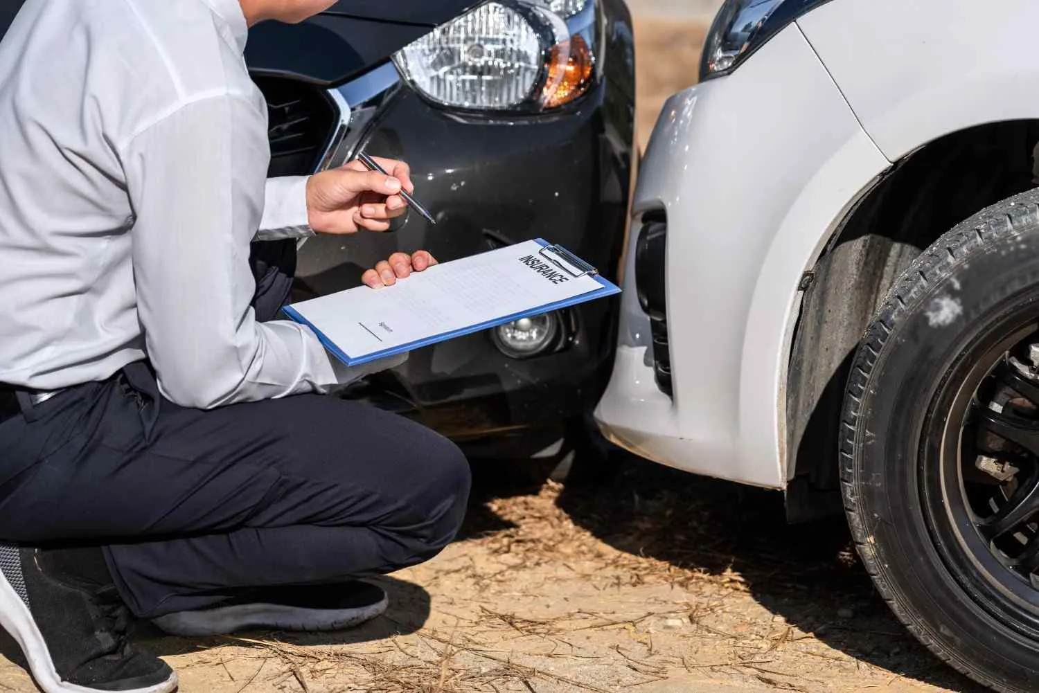 Damage on a car being checked against a clipboard